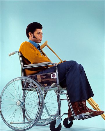 simsearch:846-02791739,k - 1970s SAD AFRICAN AMERICAN MAN SITTING IN WHEELCHAIR HOLDING CRUTCHES Fotografie stock - Rights-Managed, Codice: 846-03164996