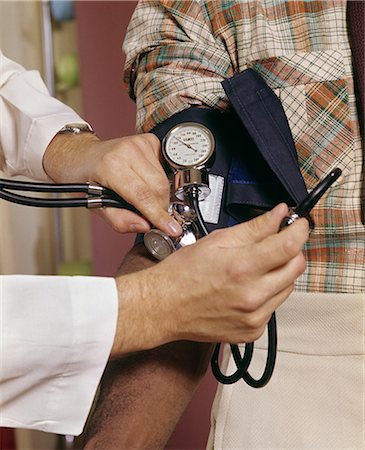 doctor vintage - 1970s CLOSE UP OF DOCTOR READING MANS BLOOD PRESSURE Stock Photo - Rights-Managed, Code: 846-03165018