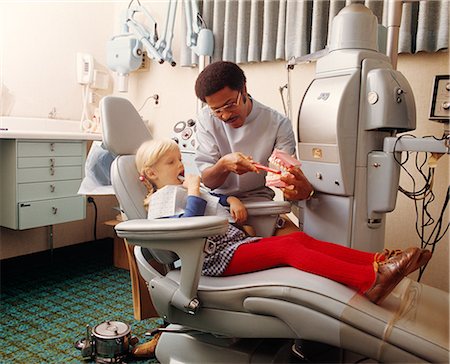 dentistry 1970s - 1970s AFRICAN-AMERICAN DENTIST TEACHING LITTLE CAUCASIAN GIRL PROPER TOOTH BRUSHING TECHNIQUE Stock Photo - Rights-Managed, Code: 846-03165020