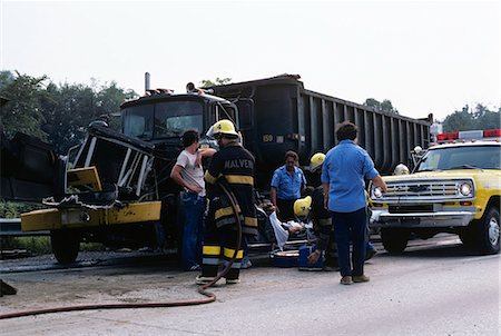 1970s FIREMEN AND EMERGENCY SERVICES ON SCENE OF TRUCK TRAFFIC ACCIDENT Foto de stock - Con derechos protegidos, Código: 846-03165030