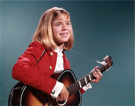 1960s SMILING BLOND TEENAGED GIRL PLAYING ACOUSTIC GUITAR Foto de stock - Direito Controlado, Número: 846-03165059