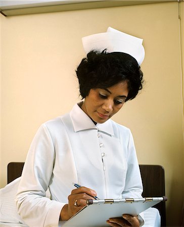 photo of black nurse in uniform - 1970s AFRICAN AMERICAN WOMAN NURSE FILLING OUT MEDICAL CHART Stock Photo - Rights-Managed, Code: 846-03165077