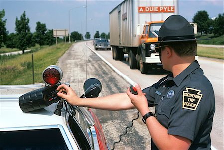 1970s POLICE OFFICER MAN OPERATING RADAR EQUIPMENT ROADSIDE CHECK FOR SPEEDING TRAFFIC Stock Photo - Rights-Managed, Code: 846-03165170