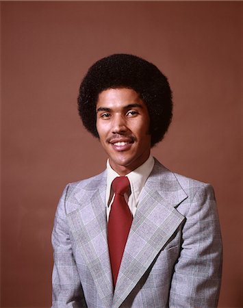 ANNÉES 1970 HOMME AFRO-AMÉRICAIN SOURIANT PORTER COSTUME CRAVATE FOND ROUGE Photographie de stock - Rights-Managed, Code: 846-03165172