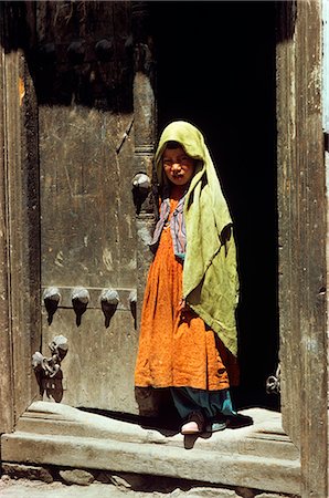 simsearch:846-03164419,k - LITTLE GIRL STANDING IN THE DOORWAY TYPICAL NEPALESE BRASS-STUDDED DOOR NEPAL Stock Photo - Rights-Managed, Code: 846-03165705