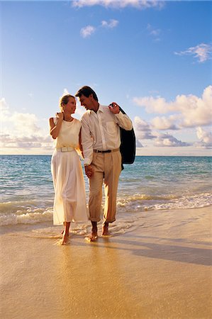 COUPLE ON THE BEACH WALKING BY THE WATER DRESSED UP Stock Photo - Rights-Managed, Code: 846-03165909