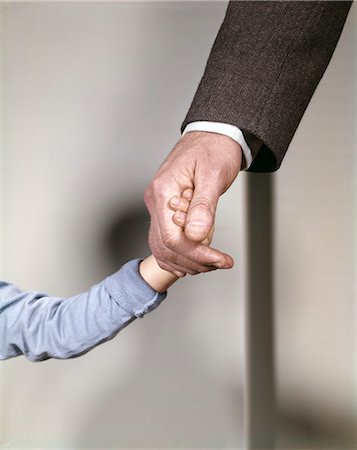 1960s ADULT MAN HAND HOLDING THAT OF SMALL CHILD TODDLER FATHER YOUNG OLD SAFETY PROTECTION GUIDANCE Stock Photo - Rights-Managed, Code: 846-03165936