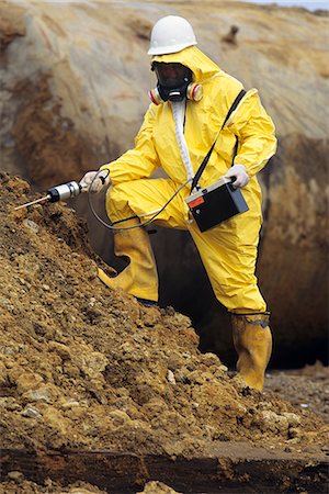 WORKER IN SAFETY GEAR CHECKING SOIL FOR OIL CONTAMINATION Foto de stock - Con derechos protegidos, Código: 846-03165952