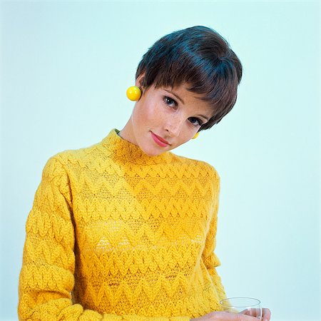 1960s BRUNETTE WOMAN SHORT PIXIE HAIR STYLE YELLOW KNIT SWEATER EARRINGS Fotografie stock - Rights-Managed, Codice: 846-03165984