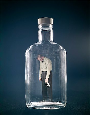 DES ANNÉES 1960 ONT CHUTÉ AU COURS DE LA BOUTEILLE DE WHISKY HOLDING HOMME COINCÉ À L'INTÉRIEUR DE L'ALCOOL ALCOOLIQUE DECANTER Photographie de stock - Rights-Managed, Code: 846-03166063