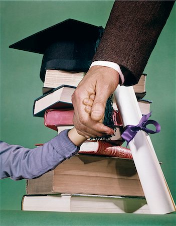 1970s COMPOSITE IMAGE STACK BOOKS BOY ADULT FATHER HANDS GRADUATION CAP DIPLOMA MORTARBOARD Stock Photo - Rights-Managed, Code: 846-03166100