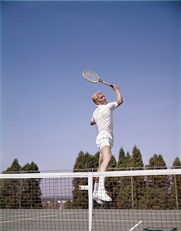 1970s MAN PLAYING TENNIS JUMPING IN MID AIR SWINGING RACKET TO HIT BALL ACTION RECREATION EXERCISE Stock Photo - Rights-Managed, Code: 846-03166124