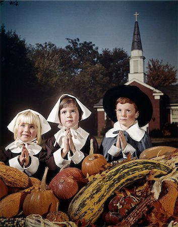 pilgrim - 1960s THREE CHILDREN WEARING PILGRIM COSTUMES SAYING GRACE BACKDROP OF CHURCH SPIRE Stock Photo - Rights-Managed, Code: 846-03166136