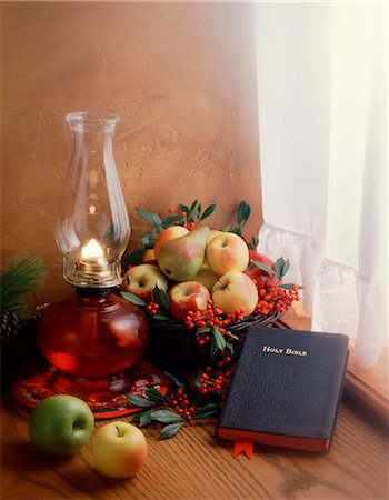 WINTER STILL LIFE BIBLE HURRICANE LAMP FRUIT BASKET IN CURTAINED WINDOW Stock Photo - Rights-Managed, Code: 846-03166198