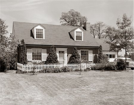 simsearch:846-02795537,k - 1950s 1960s SUBURBAN BRICK HOUSE PICKET FENCE DORMER WINDOWS CAR IN DRIVEWAY Stock Photo - Rights-Managed, Code: 846-03163230