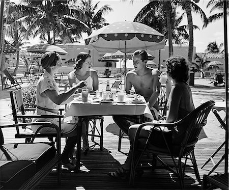 1950s THREE WOMEN AND ONE MAN SITTING AT TROPICAL POOL SIDE TABLE TALKING Stock Photo - Rights-Managed, Code: 846-03163257