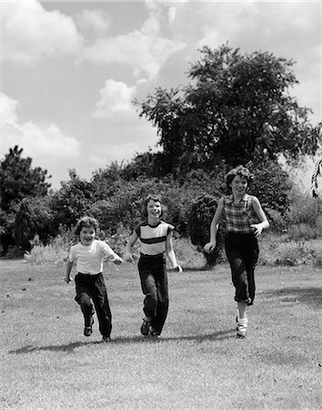 simsearch:846-02792062,k - 1950s THREE CHILDREN RUNNING ON GRASS FIELD Foto de stock - Con derechos protegidos, Código: 846-03163433