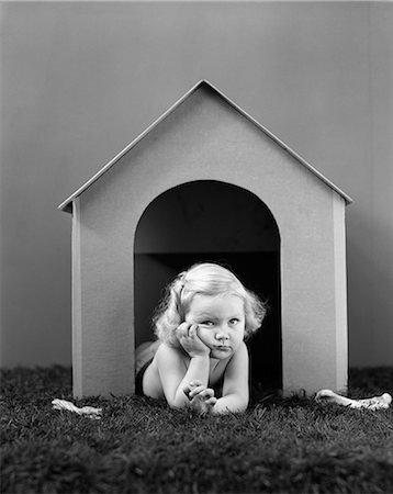 1940s CHILD IN DOG HOUSE LYING ON GRASS Foto de stock - Con derechos protegidos, Código: 846-03163489