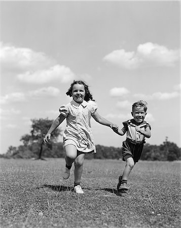 simsearch:846-03163542,k - 1940s TWO CHILDREN RUNNING PLAYING IN FIELD GRASS SMILING Foto de stock - Direito Controlado, Número: 846-03163507