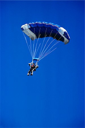 skydiver - SKYDIVER WITH OPEN BLUE AND WHITE PARACHUTE IN BLUE CLOUDLESS SKY Stock Photo - Rights-Managed, Code: 846-03163640