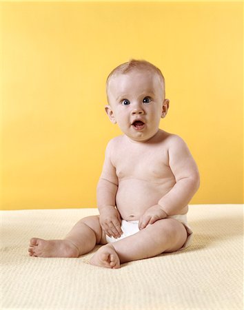 1970s BABY WEARING DIAPER SITTING ON BLANKET YELLOW BACKGROUND Stock Photo - Rights-Managed, Code: 846-03163709