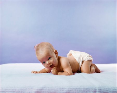 1960s 1970s BABY WEARING DIAPER CRAWLING ON BLUE BLANKET Stock Photo - Rights-Managed, Code: 846-03163711