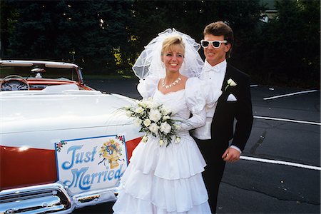 1991 BRIDE AND GROOM STANDING NEXT TO VINTAGE CONVERTIBLE FORD CAR Foto de stock - Con derechos protegidos, Código: 846-03163773