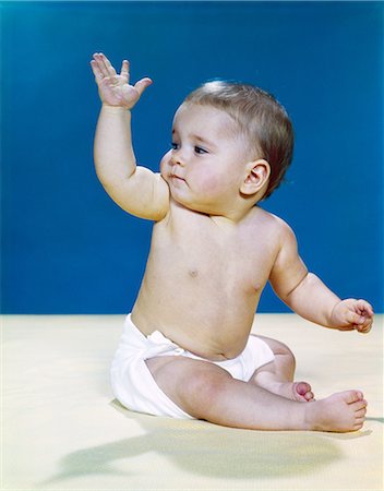 pictures of babies in vintage cloth nappies - 1960s BABY WEARING CLOTH DIAPER LOOKING OVER SHOULDER WAVING WITH RAISED ARM GESTURE Stock Photo - Rights-Managed, Code: 846-03163864