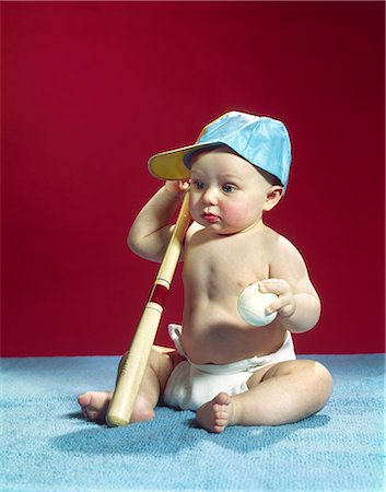 simsearch:846-02794054,k - 1960s BABY WEARING BLUE BASEBALL CAP HOLDING BALL AND BAT Stock Photo - Rights-Managed, Code: 846-03163943