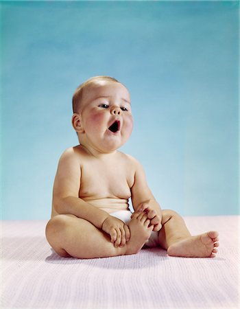 simsearch:846-03163865,k - 1960s BABY SITTING HOLDING ON TO ONE FOOT MOUTH OPEN AWE WONDER YAWN UNDERSTANDING FACIAL EXPRESSION Stock Photo - Rights-Managed, Code: 846-03163974