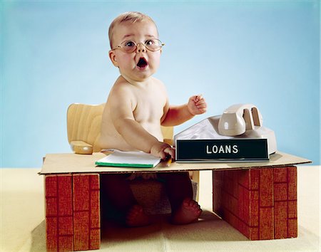 sitting baby diaper - 1960s BABY BUSINESSMAN DIAPER SITTING AT TOY DESK LOANS BANK SIGN WEARING EYEGLASSES Stock Photo - Rights-Managed, Code: 846-03163978