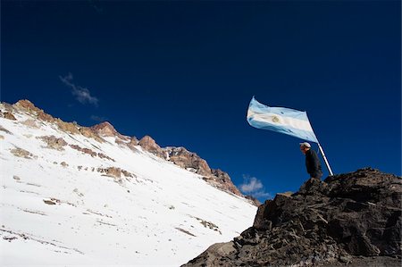 Hiker under the Argentinian flag looking up at the summit of Aconcagua 6962m, highest peak in South America, Aconcagua Provincial Park, Andes mountains, Argentina, South America Stock Photo - Rights-Managed, Code: 841-05782771