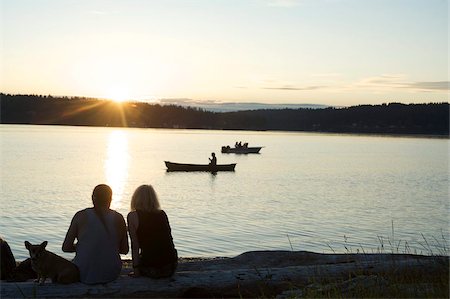 dietro - Silhouette of couple with dog watching sunset at Lisabeula Beach, Vashon Island, Washington State, United States of America, North America Fotografie stock - Rights-Managed, Codice: 841-05783362