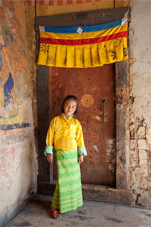 Young girl in national dress standing in doorway beneath colourful Buddhist banner at the Tamshing Phala Choepa Tsechu, near Jakar, Bumthang, Bhutan, Asia Foto de stock - Con derechos protegidos, Código: 841-05845856