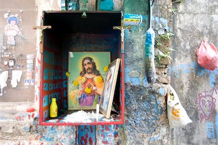 santuario - Christian shrine in wooden box on a street wall, with candle, marigolds and offerings, Colaba back street, Mumbai, India, Asia Foto de stock - Con derechos protegidos, Código: 841-05846620