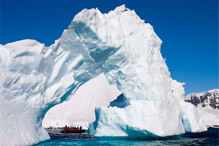 Magnificent arched iceberg with tourists in Zodiac boat underneath, Enterprise Island, Antarctic Peninsula, Antarctica, Polar Regions Stock Photo - Rights-Managed, Code: 841-05962365