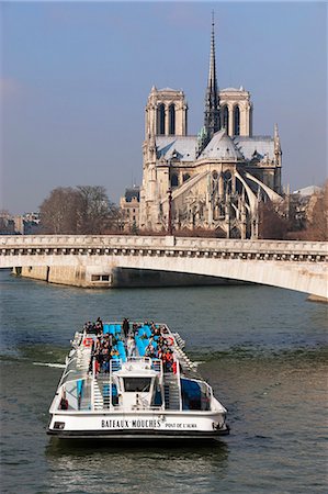 Tourist boat going under bridge on the River Seine, with Notre Dame Cathedral in background, Paris, France, Europe Stock Photo - Rights-Managed, Code: 841-06031219