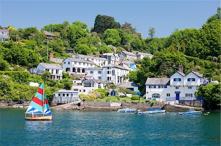 A dinghy sails past the village of Boddinick near Fowey, Cornwall, England, United Kingdom, Europe Foto de stock - Con derechos protegidos, Código: 841-06032785