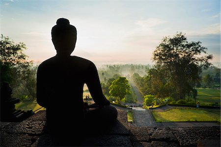 simsearch:841-07083391,k - Stone Buddha silhouetted at sunrise at Borobudur Temple, UNESCO World Heritage Site, Java, Indonesia, Southeast Asia, Asia Stock Photo - Rights-Managed, Code: 841-06341178