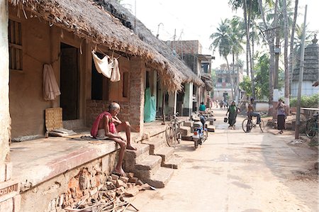 people sitting on outdoor steps - Artists houses with thatched roofs in main street of artists' village, Raghurajpur, Orissa, India, Asia Stock Photo - Rights-Managed, Code: 841-06343936
