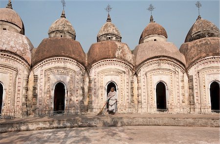 Woman with broom emerging from one of 108 Shiva temples built by Maharaja Teja Chandra Bahadur in 1809, Kalna, West Bengal, India, Asia Stock Photo - Rights-Managed, Code: 841-06447722