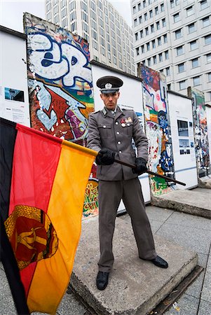 potsdamer pl - East German guard with former GDR flag in front of remains of the Berlin Wall, Potsdamer Platz, Berlin, Germany, Europe Stock Photo - Rights-Managed, Code: 841-06449497