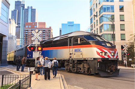 simsearch:841-06616668,k - Metra Train passing pedestrians at an open railroad crossing, Downtown, Chicago, Illinois, United States of America, North America Stock Photo - Rights-Managed, Code: 841-06616700