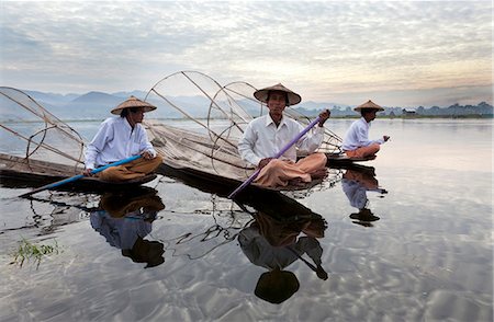 Intha leg rowing fishermen on Inle Lake who row traditional wooden boats using their leg and fish using nets stretched over conical bamboo frames, Inle Lake,Shan State, Myanmar (Burma), Asia Stock Photo - Rights-Managed, Code: 841-06805751
