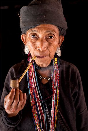 shan state - Woman of the Ann tribe in traditional black dress and colourful beads smoking a pipe in the doorway of her home in a hill village near Kengtung (Kyaingtong), Shan State, Myanmar (Burma), Asia Stock Photo - Rights-Managed, Code: 841-06805765