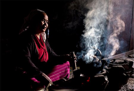 Woman of the Palaung tribe cooking on open fire in her home in village near Kengtung (Kyaingtong), Shan State, Myanmar (Burma), Asia Stockbilder - Lizenzpflichtiges, Bildnummer: 841-06805766