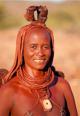 Himba woman wearing traditional leather clothing and jewellery, hair brading and skin covered in Otjize, a mixture of butterfat and ochre, Kunene Region (formerly Kaokoland) in the far north of Namibia, Africa Foto de stock - Direito Controlado, Número: 841-06805773