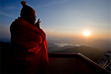 A monk looks out over a sunrise from the top of the sacred mountain Sri Pada (Adam's Peak), Sri Lanka, Asia Foto de stock - Con derechos protegidos, Código: 841-06807387