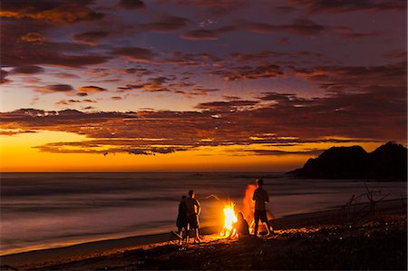 People with driftwood fire at sunset on Playa Guiones beach, Nosara, Nicoya Peninsula, Guanacaste Province, Costa Rica Stockbilder - Lizenzpflichtiges, Bildnummer: 841-06807447