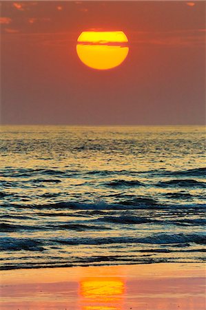 red orange sunset - The sun setting off Playa Guiones surf beach, Nosara, Nicoya Peninsula, Guanacaste Province, Costa Rica, Central America Stock Photo - Rights-Managed, Code: 841-06807480